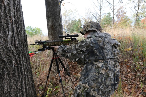 Hunter aims crossbow in woods