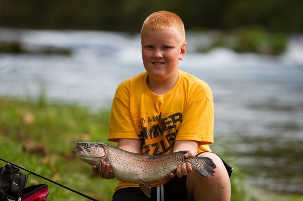 Boy holds large rainbow trout
