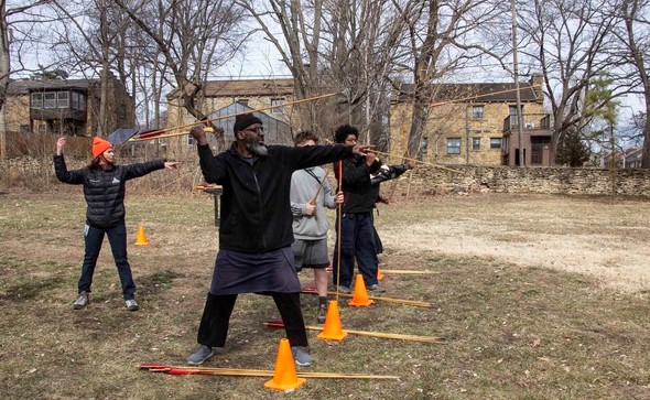 Group practices throwing an atlatl