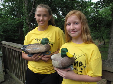 Two girls pose with duck decoys at Discover Nature Girls Camp at Wappapello Lake