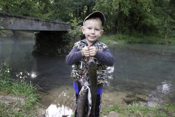Kid holding up trout.