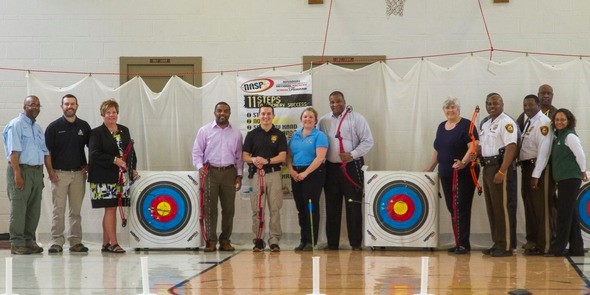 group of people posed with archery equipment