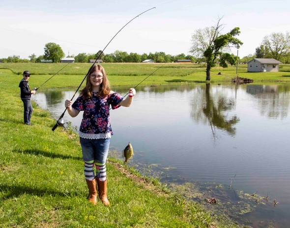 A young angler shows off her catch of the day during MDC outdoor skills field day in Rich Hill.