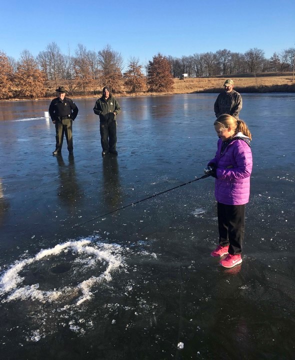 girl ice fishing on pond