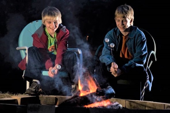 two boys at campfire
