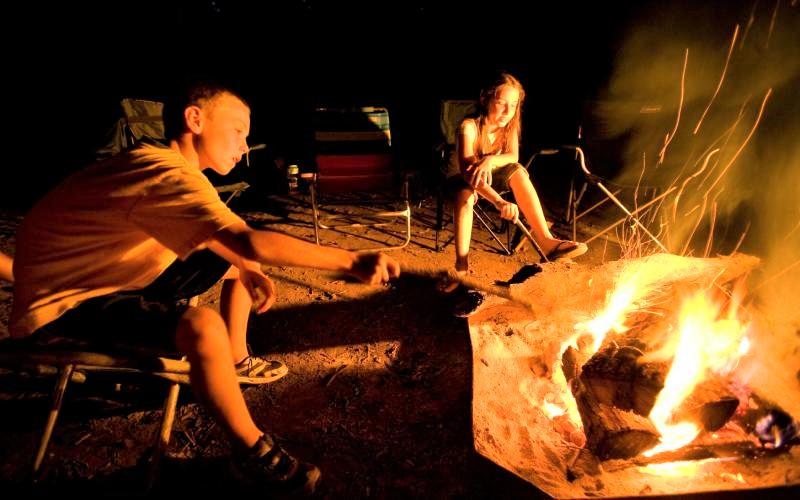 two kids at a campfire