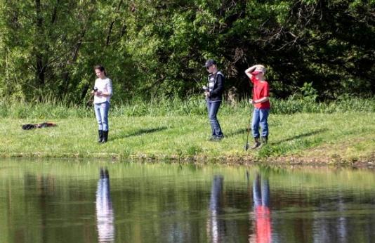 three people pond fishing