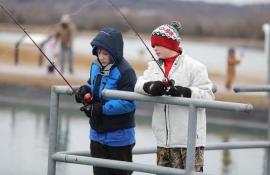 Two boys fishing in winter