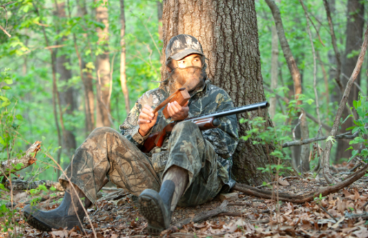 Turkey hunter calls for turkeys in woods
