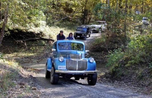 A line of vehicles take a fall driving tour through Poosey Conservation Area.