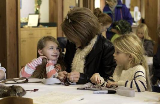 An adult and two little girls making crafts.