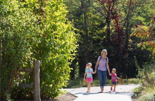 A woman and her daughter walking on a trail at the Runge Nature Center.