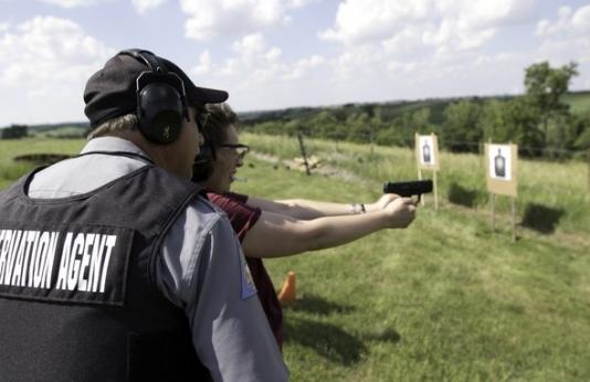 agent teaching woman to shoot handgun