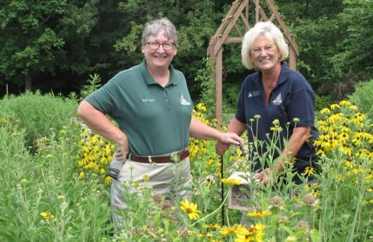 Jamie Koehler, assistant manager at the Cape Girardeau Conservation Nature Center, and Judy Lang, a nature center volunteer, install a bee hotel in a native plant garden.