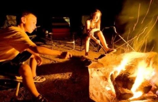 two kids around a campfire