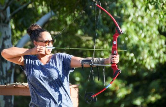 woman shooting compound bow at target